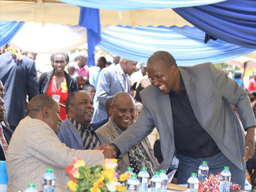 Education Cabinet Secretary Fred Matiang'i greets his brother John Matiang'i, who is Knut national treasurer, during prize giving day at Nyambaria Boys' High School in Kitutu Masaba constituency, March 27, 2016. Photo/ANGWENYI GICHANA