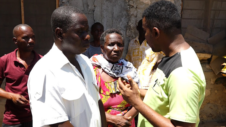 James Luwali with his mother Josephine Nzingo listen to Mathias Shipeta of Haki Africa when they visited their home in Mjanaheri, Magarini subcountyof Kilifi county.