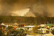 An Air-crane water bombing helicopter drops water on a bushfire in Harrington, Australia, November 8, 2019. 