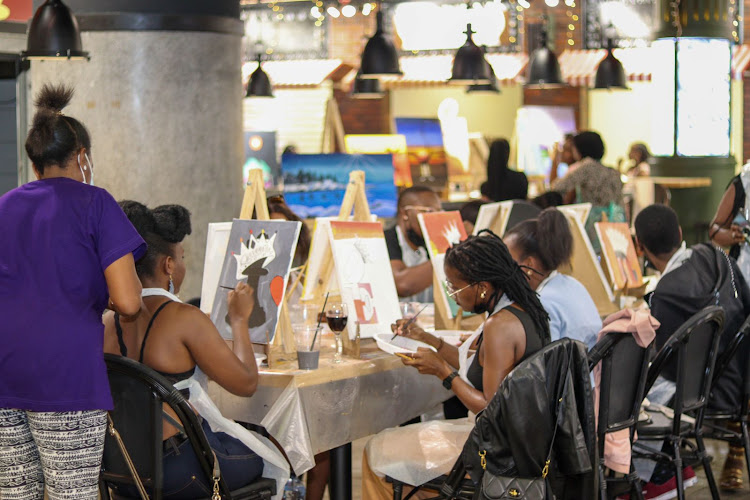 Attendees enjoy paint and sip at the pop up market