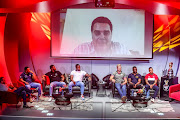 Rassie Erasmus on screen with representative players of Griquas, Bulls, Sharks, Cheetahs, Pumas, Stormers and Lions sitting below him during the Currie Cup announcement at The Venue, Melrose Arch on November 03, 2020 in Johannesburg, South Africa. 