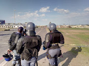 Police man a checkpoint in the coastal town of Hermanus to prevent residents gathering outside the local court when an alleged protest leader appeared on 19 July 2018. 