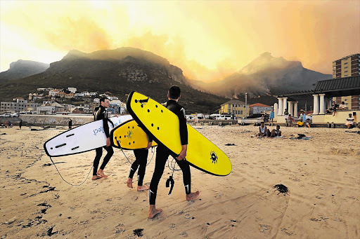 APOCALYPSE LATER: Surfers found relief from the heat in Muizenberg while the mountain fire continued