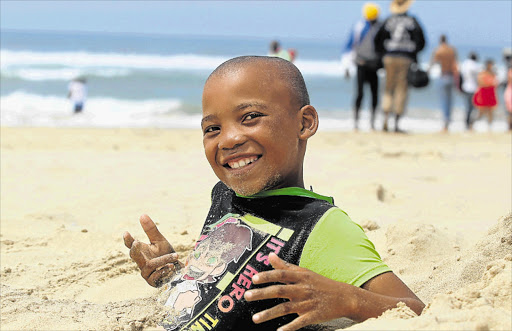 BLISS: Liyema Solani chills in the sand on Eastern Beach during the last few hours of 2015. Beaches are expected to be packed over New Year for the length of the coast, and authorities have beefed up safety measures Picture: SIBONGILE NGALWA