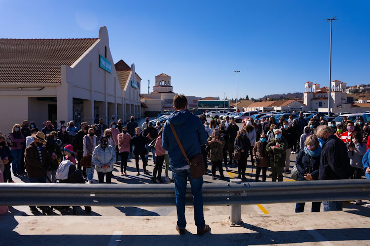 At The Glen Shopping Centre on Sunday, scores of people gathered to sing a hymn and the national anthem.