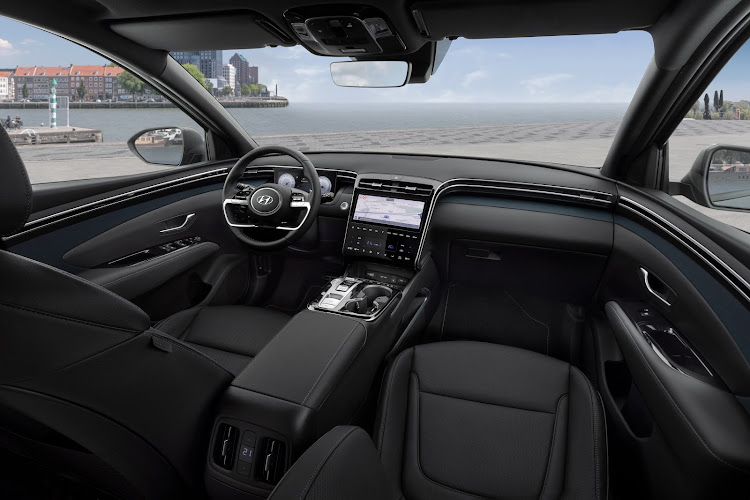 The broad ridge of the dashboard blends with the doors, wrapping around front occupants like a deep gorge.