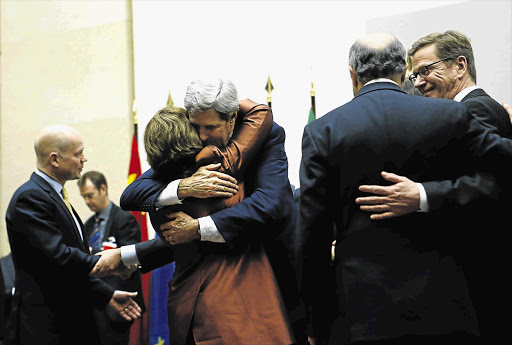 WARM EMBRACE: US Secretary of State John Kerry hugs EU foreign policy chief Catherine Ashton at the UN in Geneva at the weekend. Iran and six world powers reached a breakthrough agreement early yesterday to curb Teheran's nuclear programme in exchange for limited sanctions relief Picture: