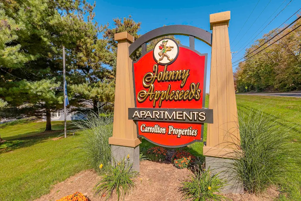 Property sign with landscaping and trees nearby.