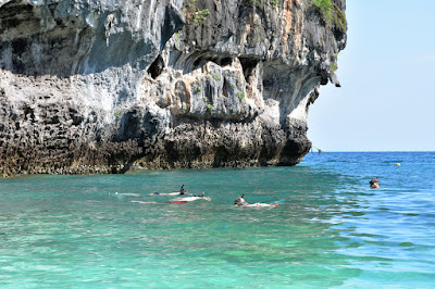 Snorkel in crystal clear water surrounded by vertical cliffs