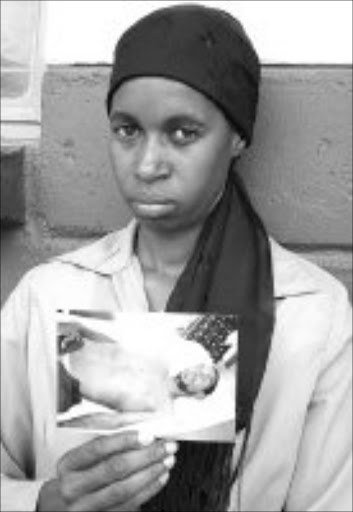 SAD: Nelisiwe Tshabalala, Amos Rathethe's sister, holding Amos's picture. Pic. Andrew Hlongwane. © Sowetan.