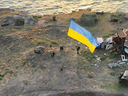 Ukrainian service members install a national flag on Snake (Zmiinyi) Island, as Russia's attack on Ukraine continues, in Odesa region, Ukraine, in this handout picture released July 7 2022.