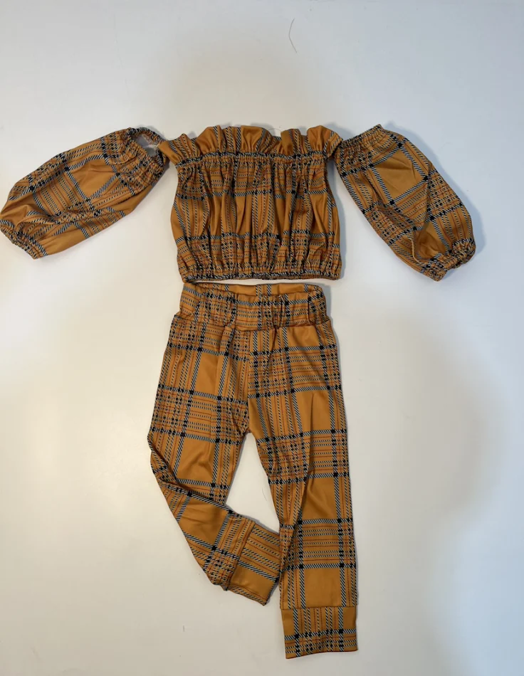 Karirane pantalone sa jednim ramenom i dugim rukavima dvodelni komplet. Elegantan i moderan, idealan za svaku priliku.