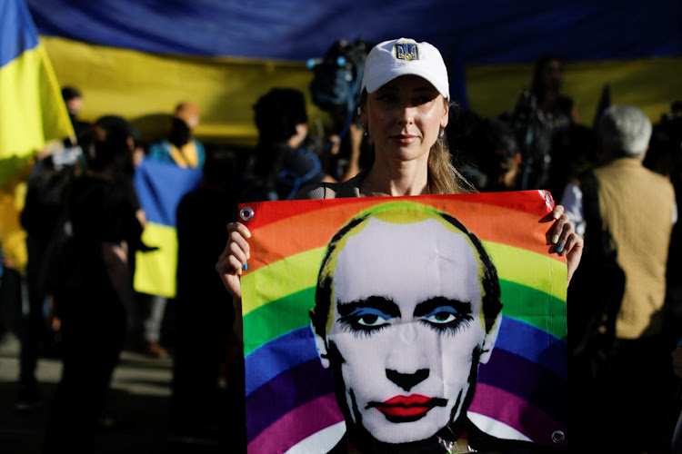 A woman holds a banner depicting Russian President Vladimir Putin as Ukrainians and supporters hold an anti-war protest outside the Russian Embassy, following Russia's invasion of Ukraine, in Mexico City, Mexico on February 28 2022. Picture: REUTERS/LUIS CORTES