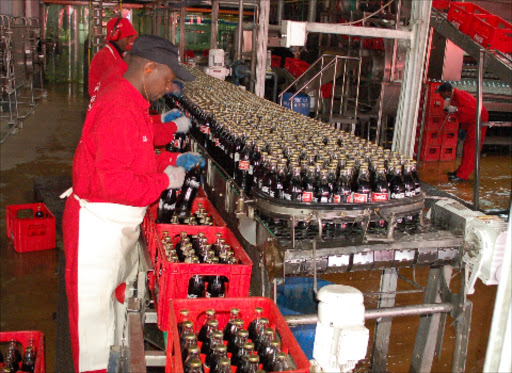 Workers at a local bottling plant pack Coca Cola sodas into crates ready for delivery to the market.FILE