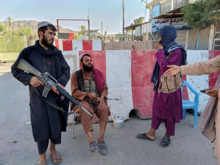 Taliban fighters stand guard at a check point in Farah, Afghanistan August 11, 2021.