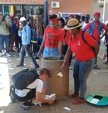 University of the Free State (UFS) student Eckhard Binding seems unfazed as he tries to dispose of rubbish, only for two women in EFF T-shirts to throw it out.