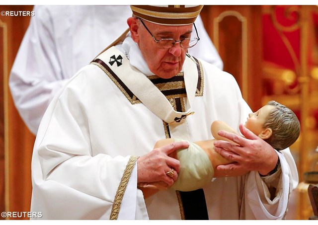 Pope Francis holds a statue of the Baby Jesus during the Christmas "Mass during the Night" - REUTERS