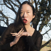 Googler Aubrie Lee (she/her) sits in a wheelchair with her hands clasped