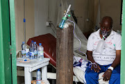 A patient breathes oxygen from an old tank at the St. Joseph COVID-19 treatment centre in Kinshasa, Democratic Republic of Congo, December 24, 2021. Picture taken December 24, 2021. 