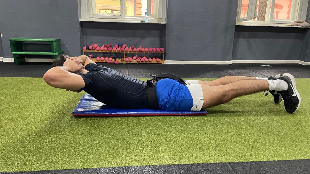 Vanja performs a back extension exercise for the lower back in the commercial gym setup.