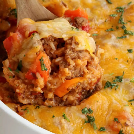 This quick and easy Stuffed Pepper Casserole Recipe combines ground beef, onions, bell peppers, fire roasted tomatoes, and rice all cooked in a perfect blend of spices and covered in melted cheddar cheese and Monterey Jack cheese.