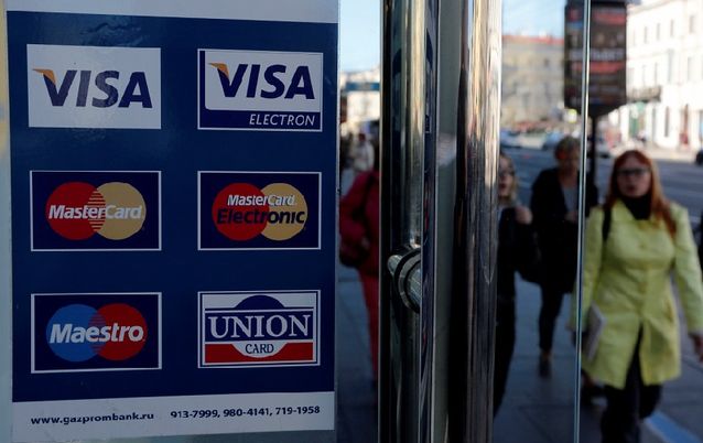 A Gazprombank sign for Visa, MasterCard and Union Card on the door of a shop in St Petersburg. Picture: REUTERS