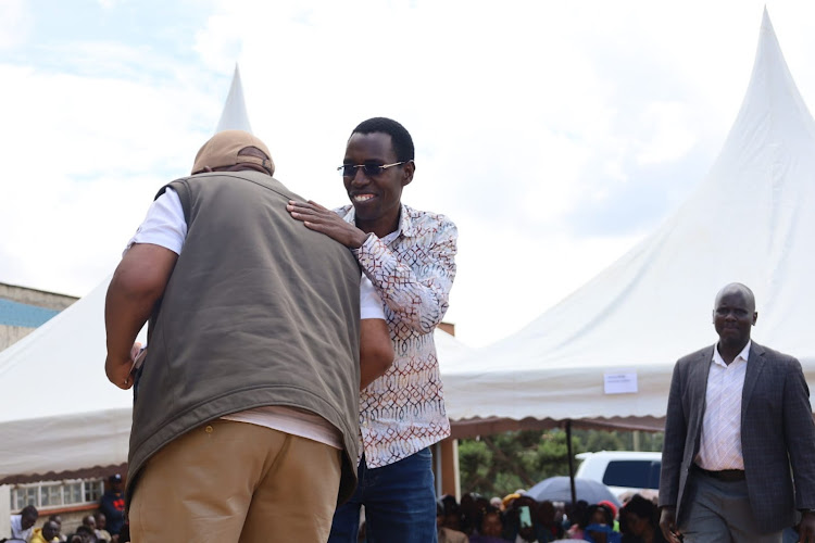 Lari MP Mburu Kahangara welcomes Kabete MP Githua Wamacukuru (in glasses) at Kimende