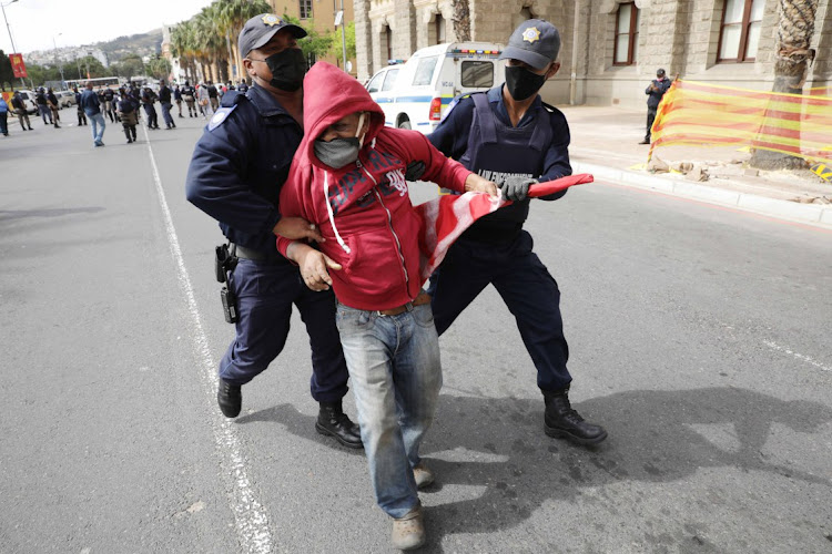 Police tackle one of the protesters in Cape Town.