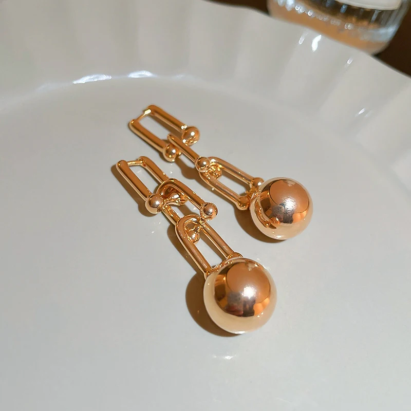 Boucles d'oreilles spéciales pour femmes avec chaînes et perles rondes, un accessoire élégant pour sublimer votre look et attirer l'attention.