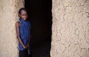 A Chadian girl stands next to door of a house at a slumdog of N'djamena, Chad on June 22, 2015. The marriage of young girls is still a common practice in Chad. From a legal point of view, the legal age of marriage is set at 15 years for girls and 18 years for boys. However in customary law, the age of marriage is implicitly set at 13 years.