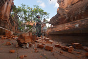 An Indonesian soldier looks at a Hindu temple damaged following an earthquake in Denpasar, Bali, Indonesia, July 16, 2019.