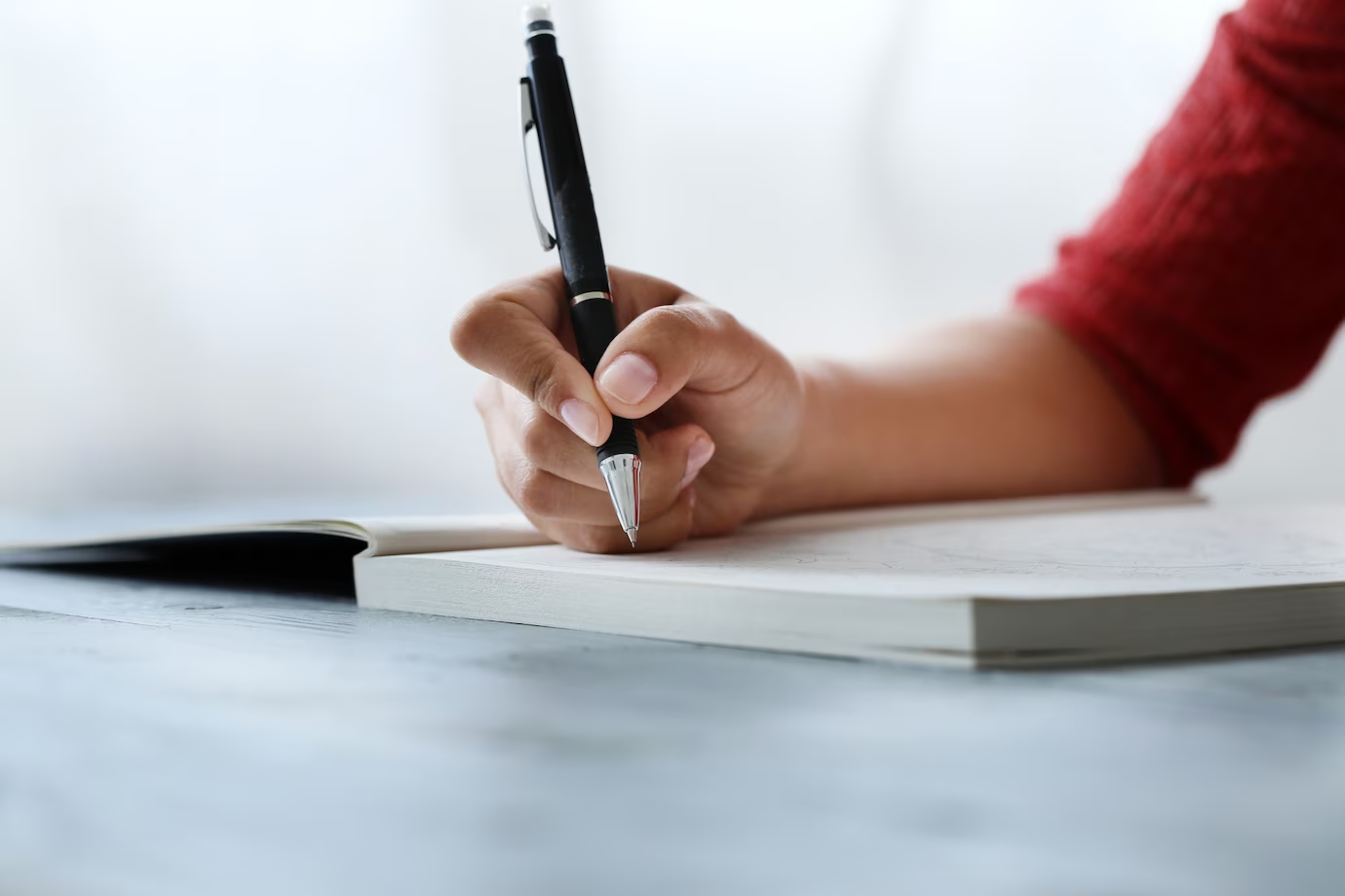 A person writing on a notebook