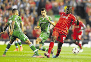 GAME-BREAKER: Mario Balotelli of Liverpool, right, battles with Anicet Abel of Ludogorets in the Uefa Champions League Group B match at Anfield last night. Balotelli scored the opening goal in his team's 2-1 victory over the Bulgarian champions