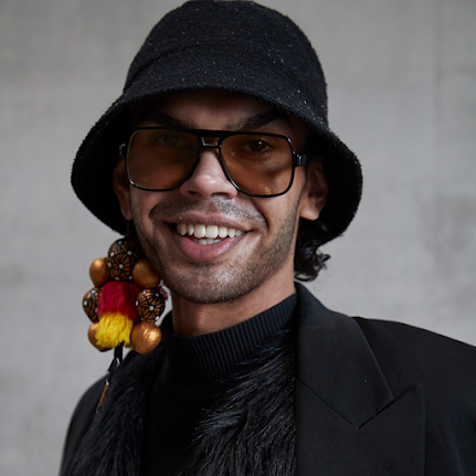 Image of Felicia Foxx from the shoulders up wearing a black bucket hat, sunglasses and one earring.