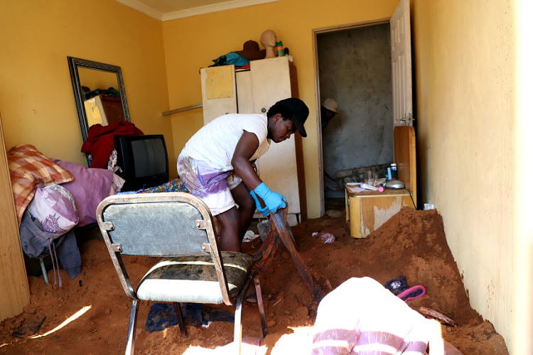 Bongani Letele helps remove the soil that was used to cover four bodies in the house at Vlakfontein, in the south of Johannesburg, in October 2018