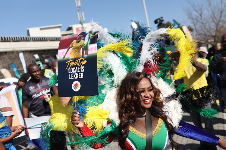 Fans celebrate while they wait for the arrival of the national women's football team at OR Tambo International Airport.