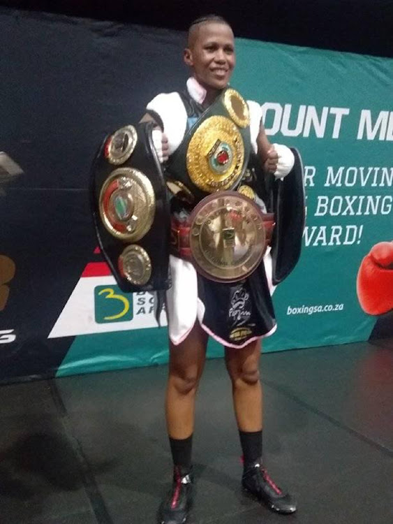 Sharadene Fortuin displays her belts after defeating Melissa Miller on Saturday.