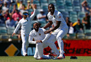 Australia v South Africa - First Test cricket match - WACA Ground, Perth, Australia - 6/11/16 South Africa's Temba Bavuma is held by team mate Kagiso Rabada as they appeal for a run out to dismiss Australia's David Warner at the WACA Ground in Perth.    REUTERS/David Gray