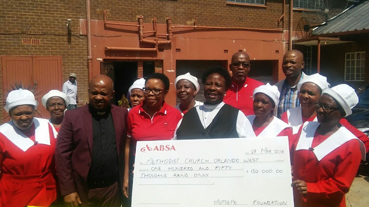 Reverend Nomsa Nomqolo (in black and white, holding the cheque) of the Orlando West Methodist Church full of joy after receiving R150 000 from Motsepe Foundation at an event held in Regina Mondi, in Soweto.