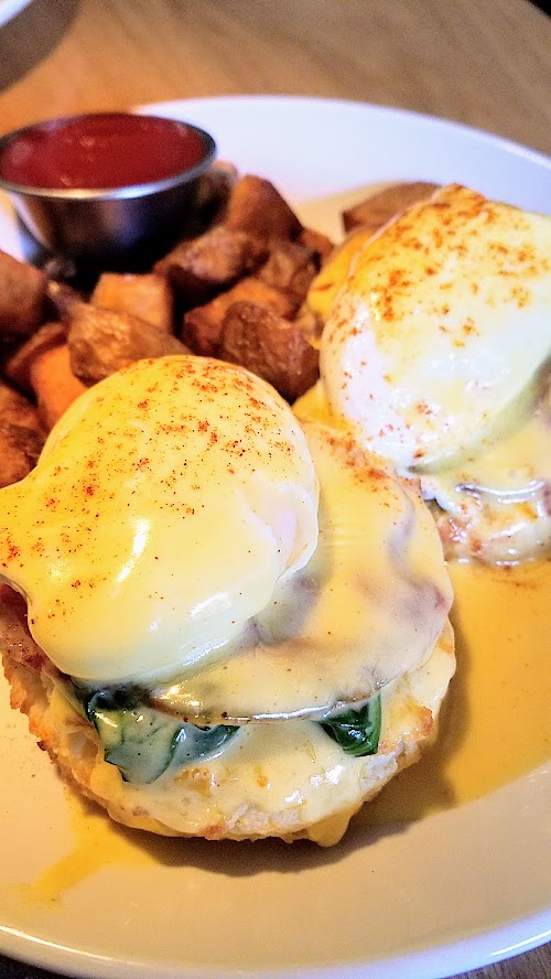 Circa 33 brunch dish of Circa Benedict with housemade biscuit, coppa, poached eggs, béarnaise, house potatoes