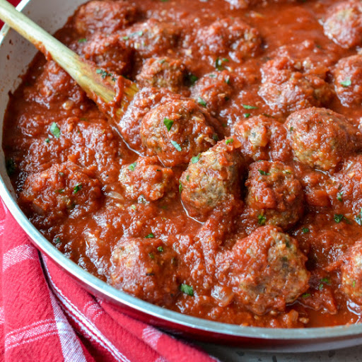 Delectable baked meatballs made with ground beef and Italian sausage all simmered in a mouthwatering good homemade marinara sauce with fresh basil.  