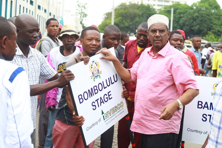 Matatu operators at Likoni Matatu Terminus receive a terminus board from MOA coast coordinator Salim Mbara on May 28