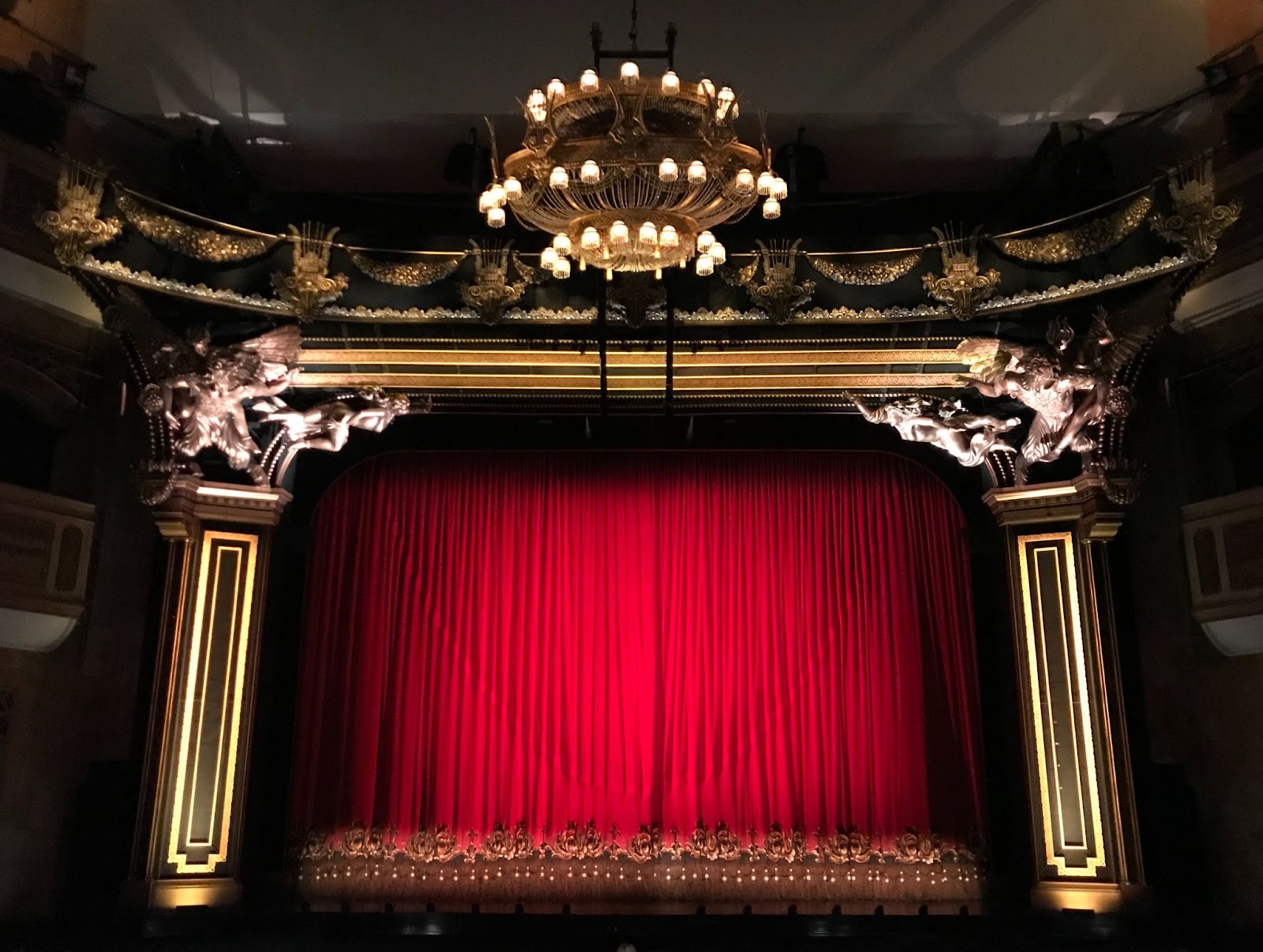 The bright red curtains of a stage musical theatre, the curtains are closed.