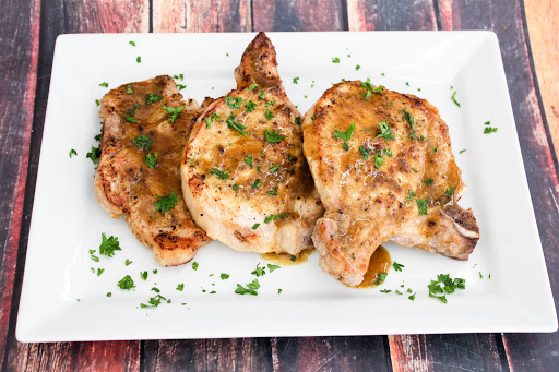 Three Maple Mustard Pork Chops on a plate.