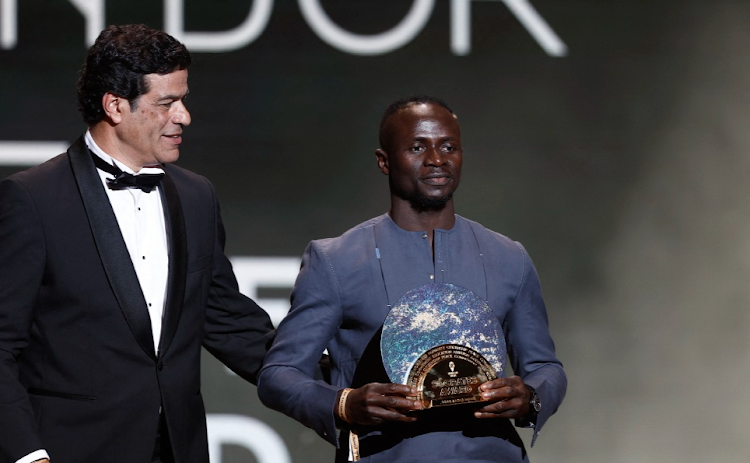 Former player Socrates's brother Rai, left, presents The Socrates Award to winner Bayern Munich's Sadio Mane at the 2022 Ballon d'Or in Paris, France, on October 17 2022. Picture: REUTERS/BENOIT TESSIER