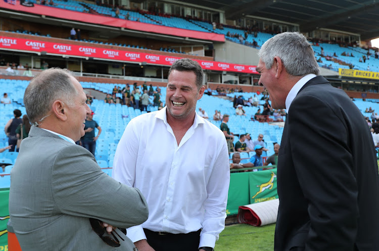 The Springboks coach and SA Rugby head of rugby Rassie Erasmus (C) in good spirits as he chats with TV commentators and analysts Naas Botha (L) and Nick Mallett (R) during the Rugby Championship match between South Africa and New Zealand at Loftus Stadium in Pretoria on October 6 2018.