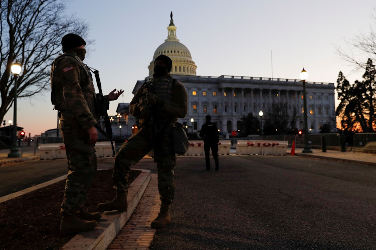 US National Guard members speak as they guard the US Capitol Building on Capitol Hill in Washington, US, January 13, 2021.