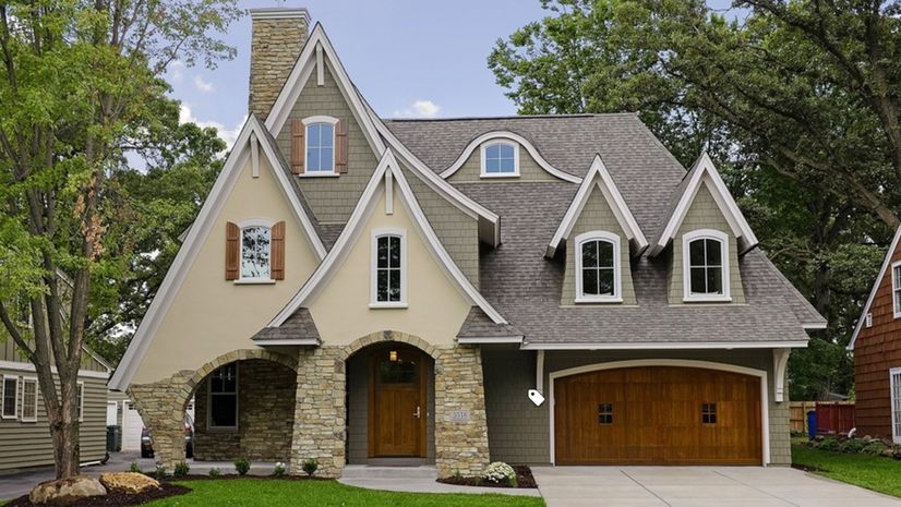 storybook style home with wooden garage doors