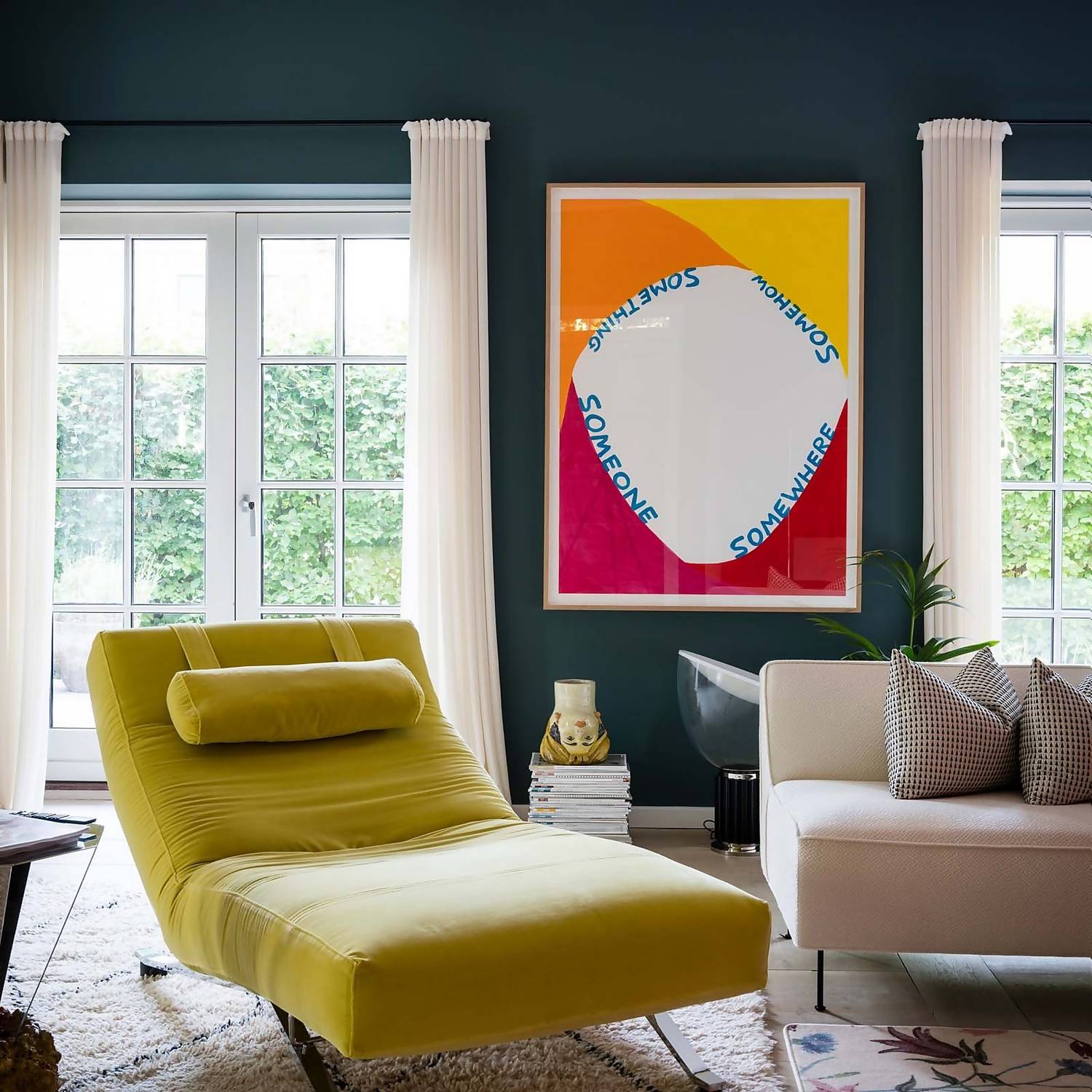 Living room painted in Inchyra blue with white curtains and colourful accessories