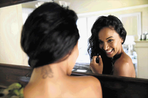 UNDER COVER: Kelly Davids pulls her hair aside to display her tattoo after she was disqualified from the Miss SA pageant